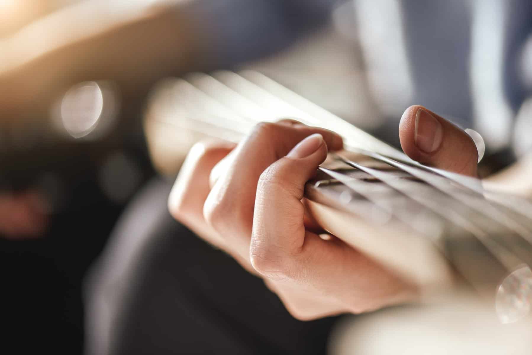 Guitar lessons. Close-up photo of male playing guitar
